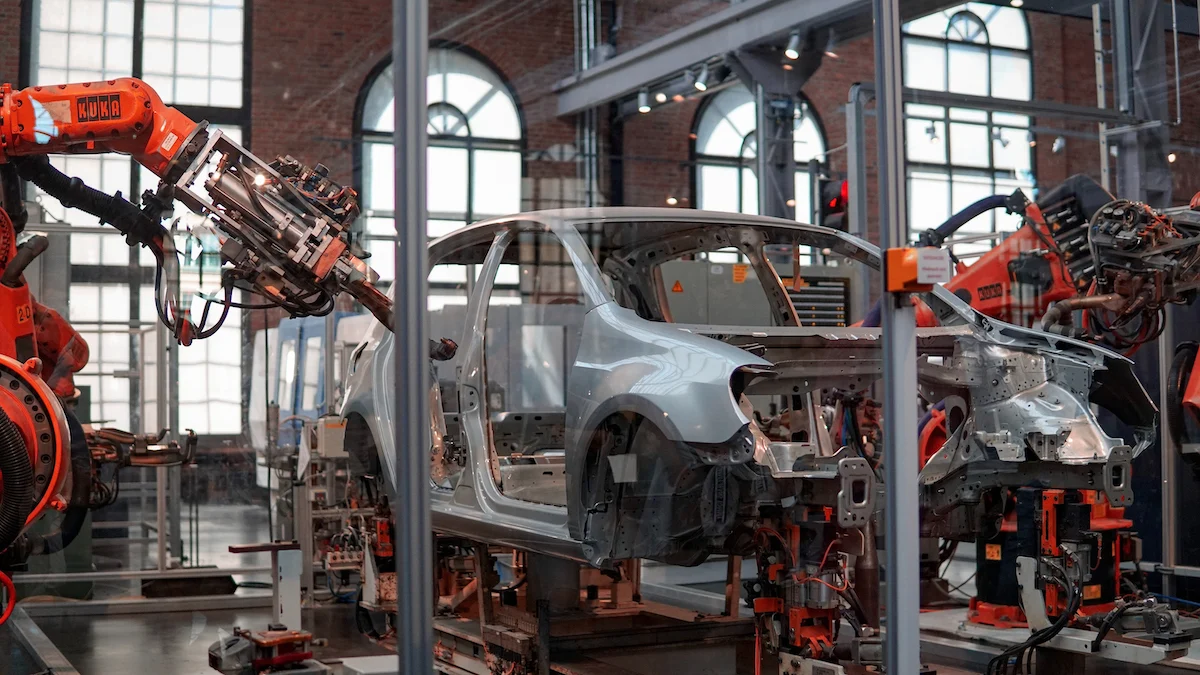 工廠內機器人在汽車上工作的照片