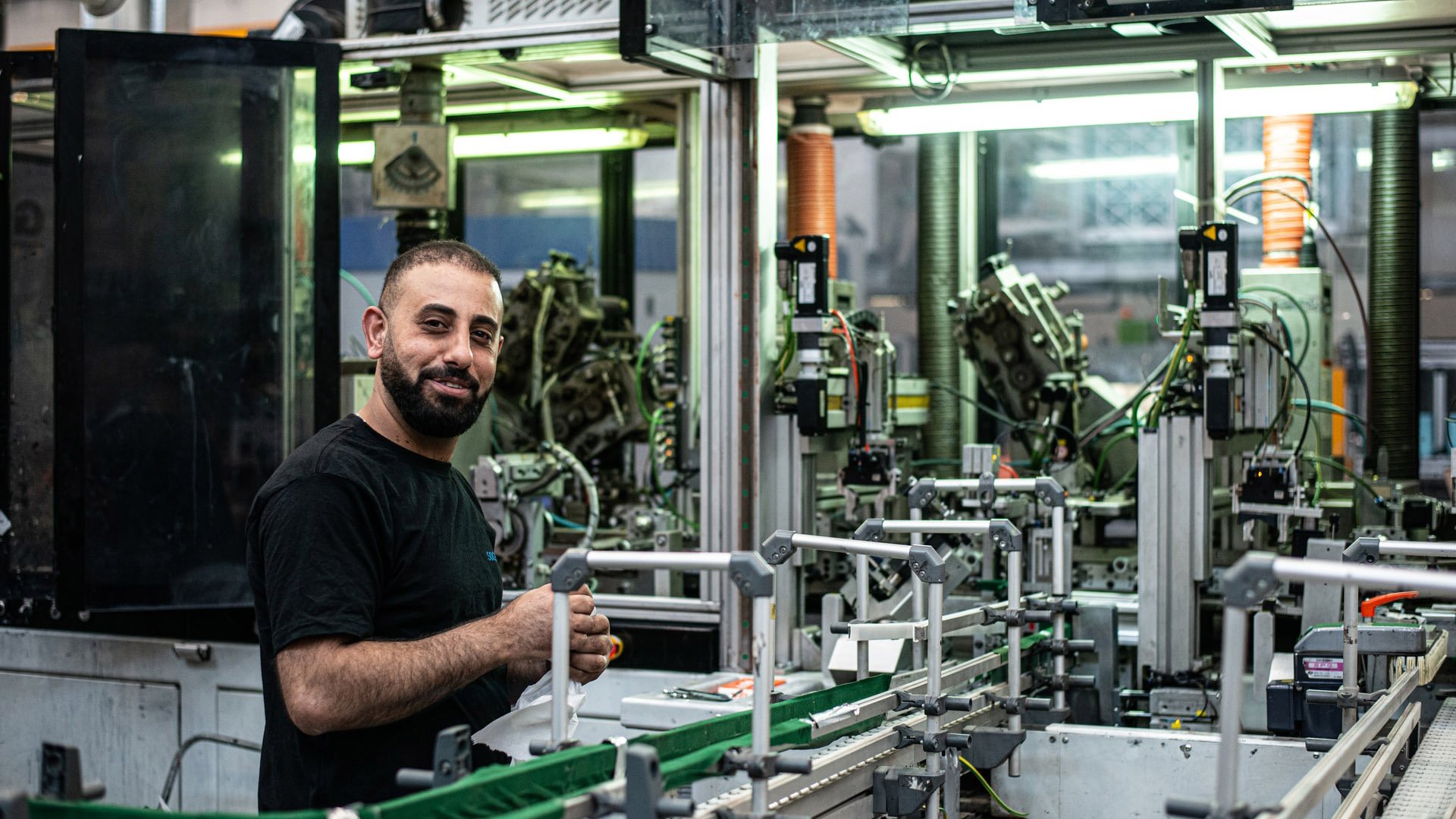 factory worker looking at the camera with machinery around him