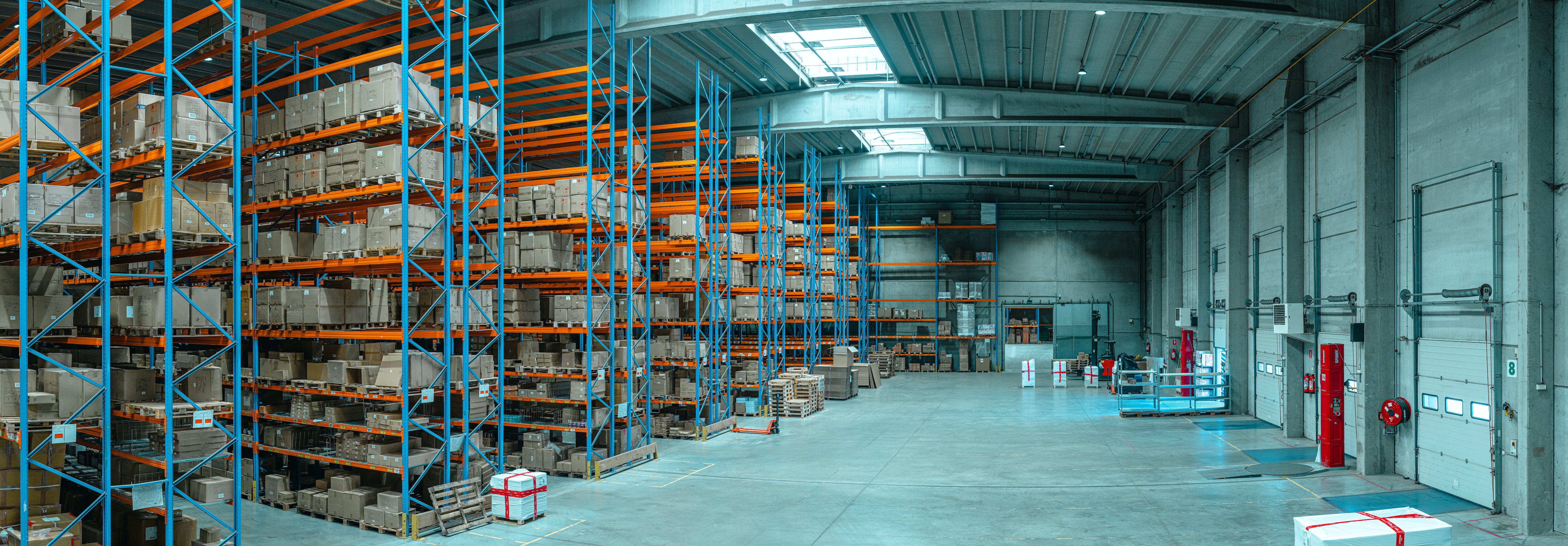 A warehouse filled with boxes on shelves A warehouse filled with boxes on shelves